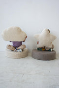 children sitting on large boucle poufs with boucle cloud cushion and boucle star cushion in hands  