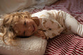 Qute little boy lying on teddy letter cushion by bettys home on his bed