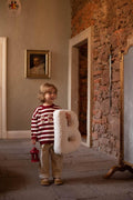 Boucle letter cushion B Teddy pillow by bettys home held by Young boy with red stipe sweater in hands 