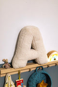 Boucle letter cushion A teddy pillow by bettys home standing on shelf in kids room next to maileg mouse