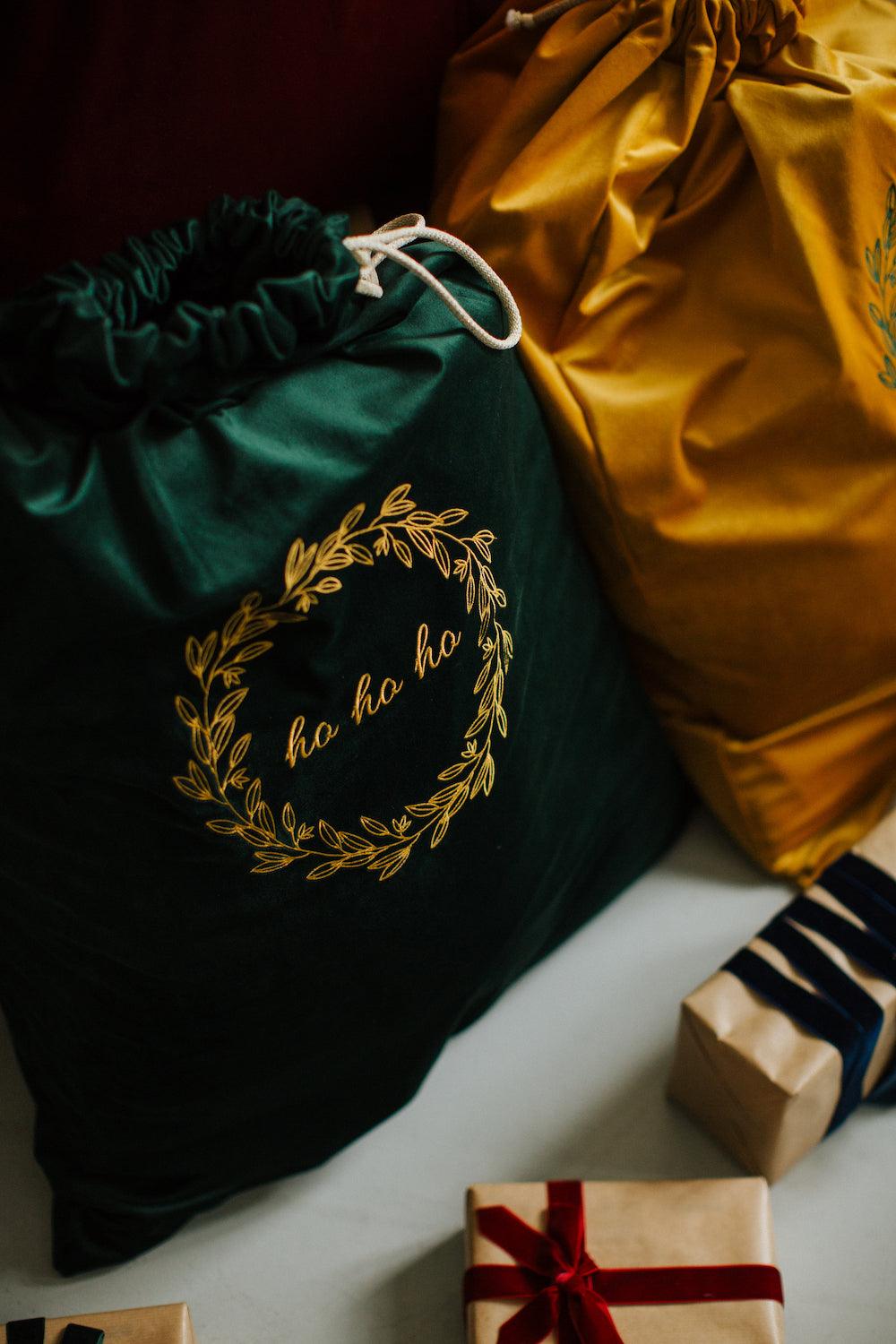 Green Christmas Bag standing next to yellow Christmas sack near to presents. Santa Sacks by Bettys Home