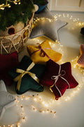 velvet small star cushion wine red by bettys home wrapped in a gold ribbon under the Christmas tree 