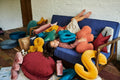 cute girl playing with velvet letter cushions by bettys home on sofa