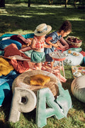 two little girls playing in garden at front of them are two velvet letter cushions P and A by bettys home 