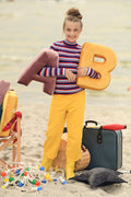 view of girl on beach with velvet letter cushion b yellow by bettys home