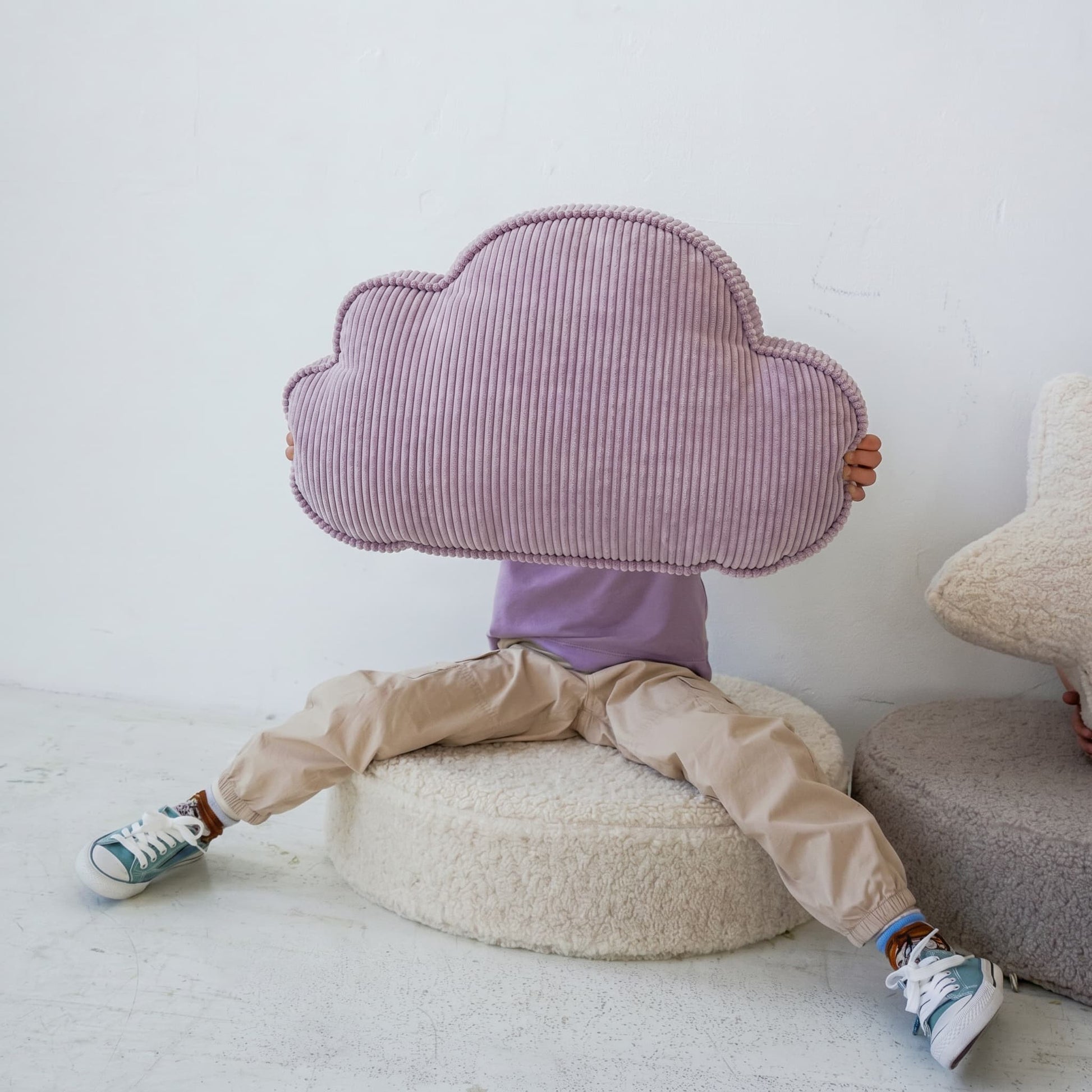 Corduroy Cloud Cushion by Bettys home. cushion in shape of cloud lavender hold by little kid