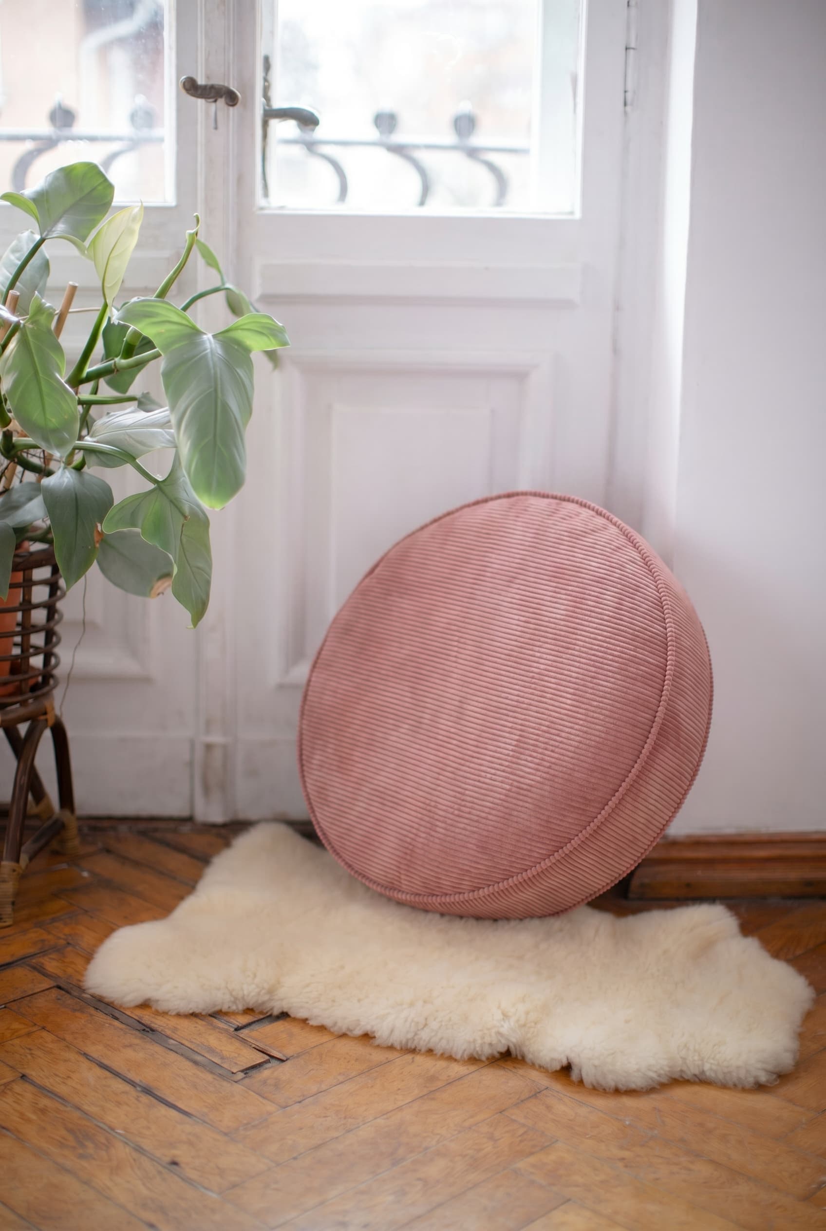 large corduroy floor pouf pink by Bettys home in living room on floor