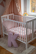 corduroy letter cushion K by bettys home in kids room on floor in front of crib. Cushion in shape of letter