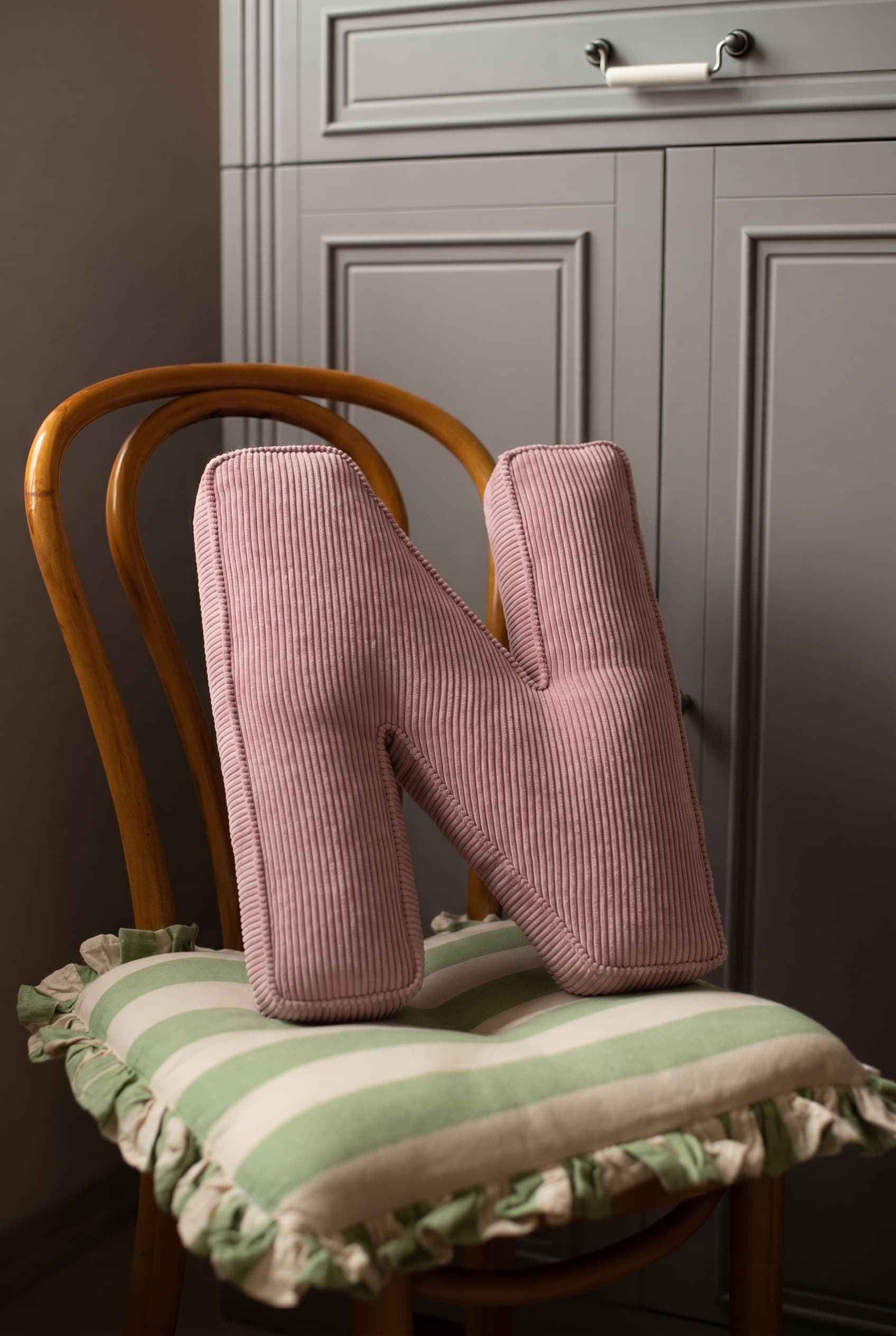 corduroy letter cushion N by bettys home in kids room on chair. Cushion in shape of letter