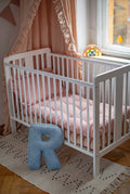 corduroy letter cushion R by bettys home in kids room on floor next to crib. Cushion in shape of letter