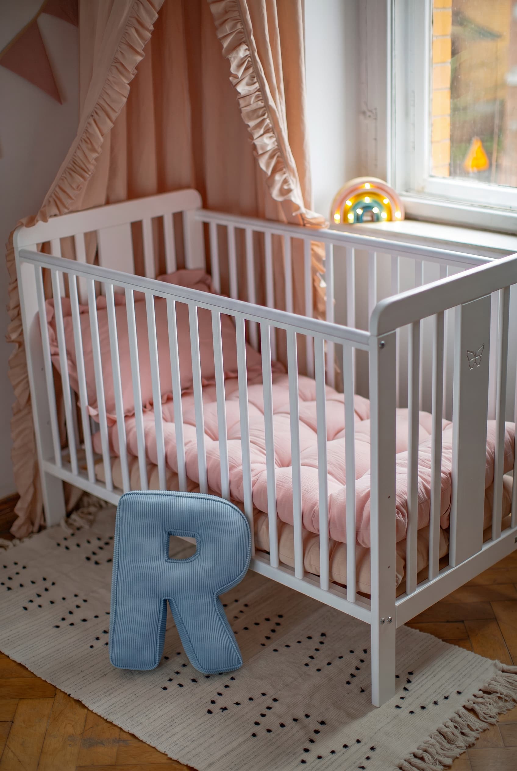 corduroy letter cushion R by bettys home in kids room on floor next to crib. Cushion in shape of letter