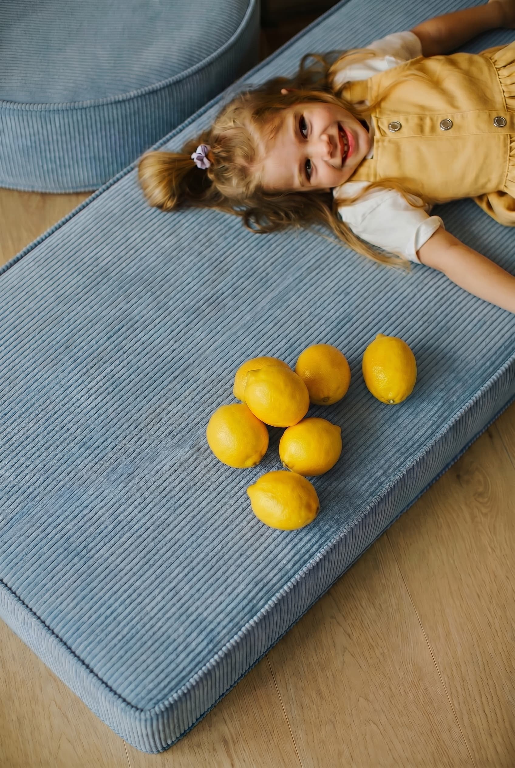 child on corduroy mattress blue by Bettys home. on mattress there are also lemons 