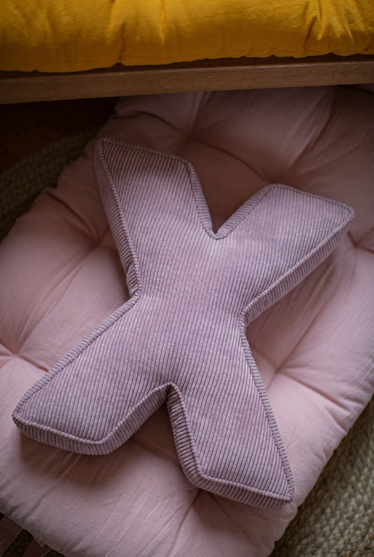 corduroy letter cushion X by bettys home in kids room on mattress. Cushion in shape of letter