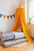 Kids' bed with yellow canopy tent, ampersand cushion and mocha bouclé floor mattress underneath – by Bettys Home
