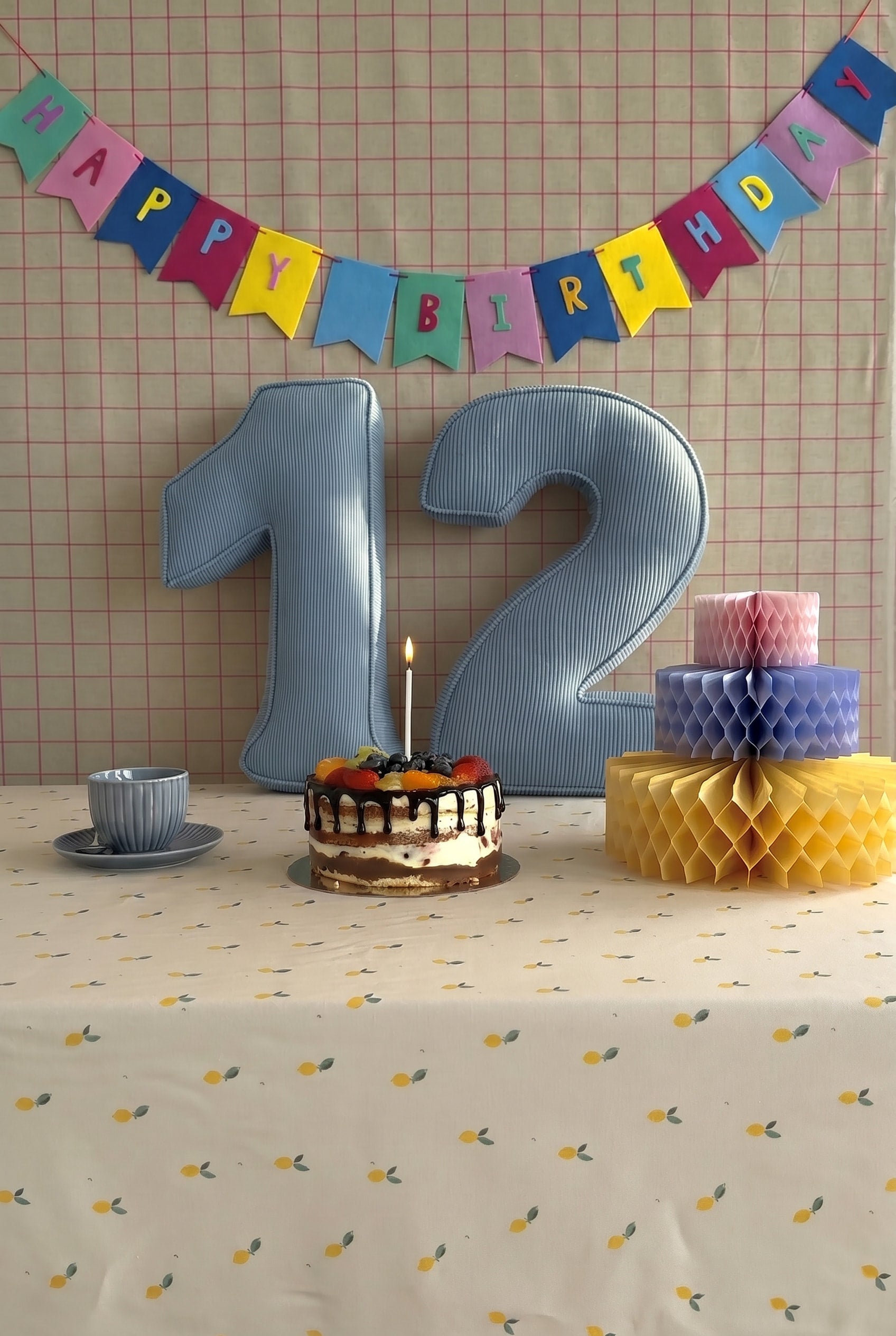 Corduroy Number Cushion by Bettys Home on birthday table with cake