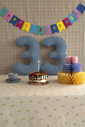 Corduroy Number Cushion by Bettys Home on birthday table with cake