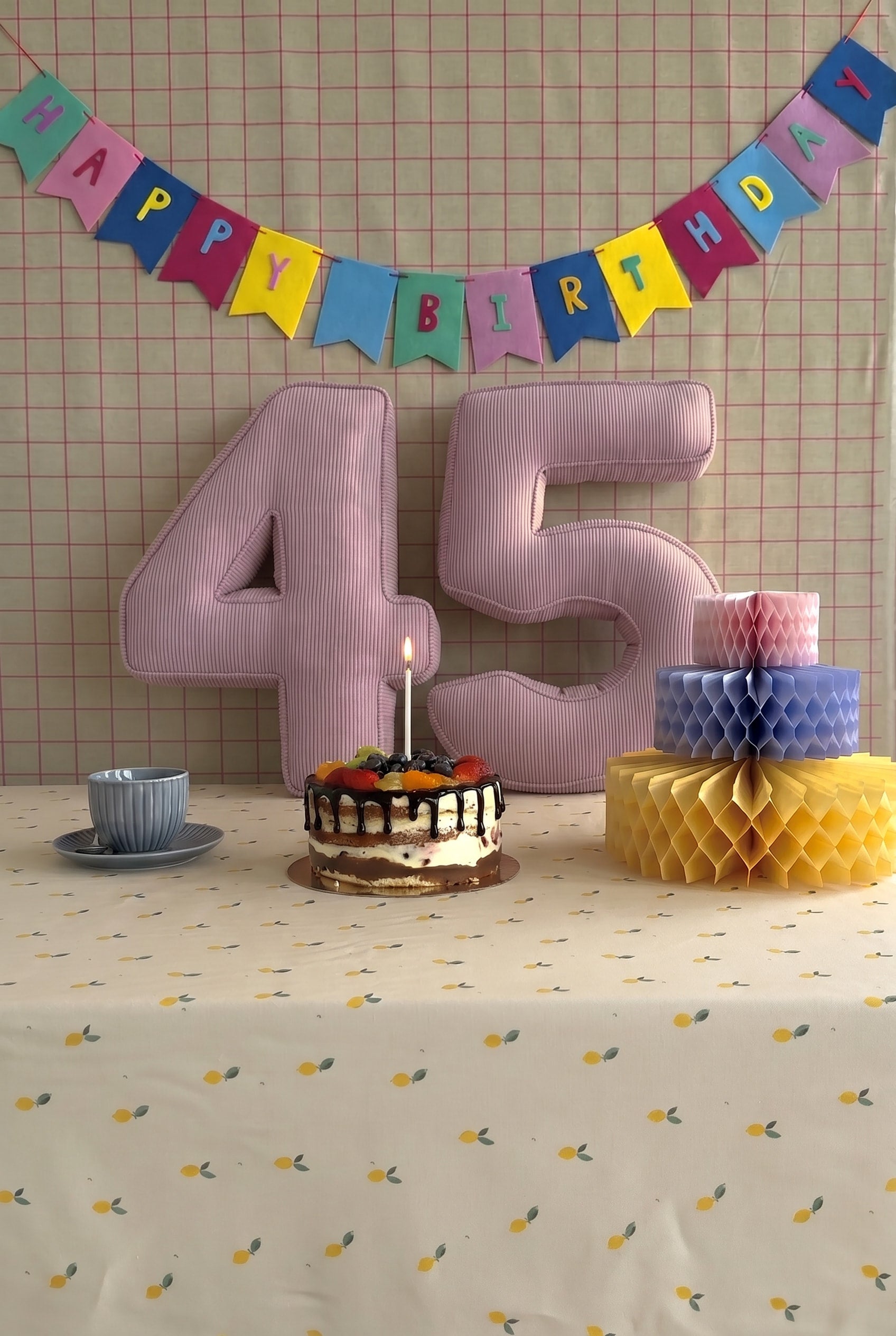 Corduroy Number Cushion by Bettys Home on birthday table with cake