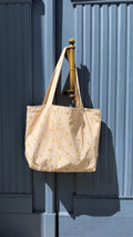 cotton tote bag with ruffle by Bettys home and lemon print hanging on blue doors
